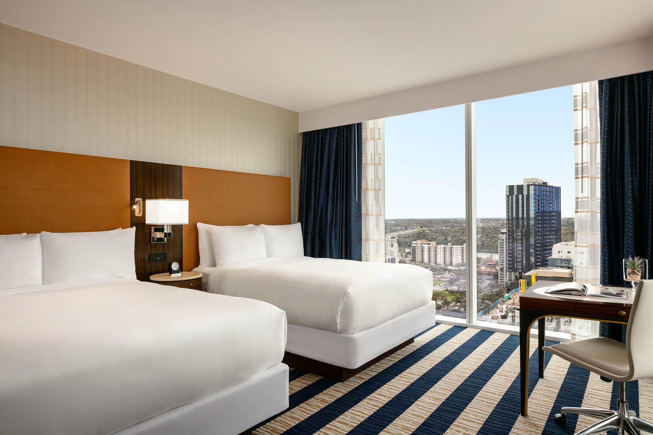 A Fairmont Austin Hotel suite with two beds and city