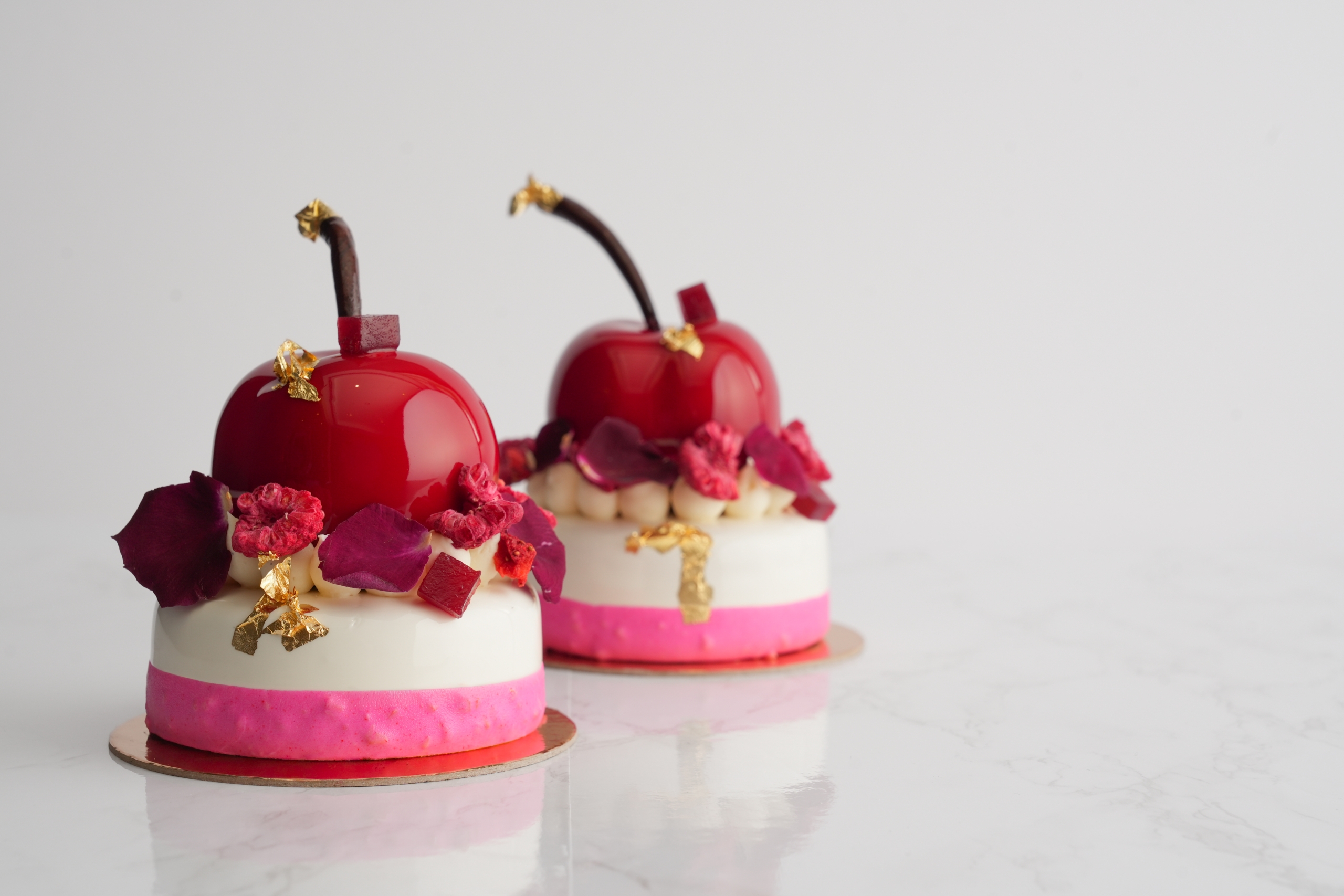 Two cherry tarts from Good Things sit on a marble table